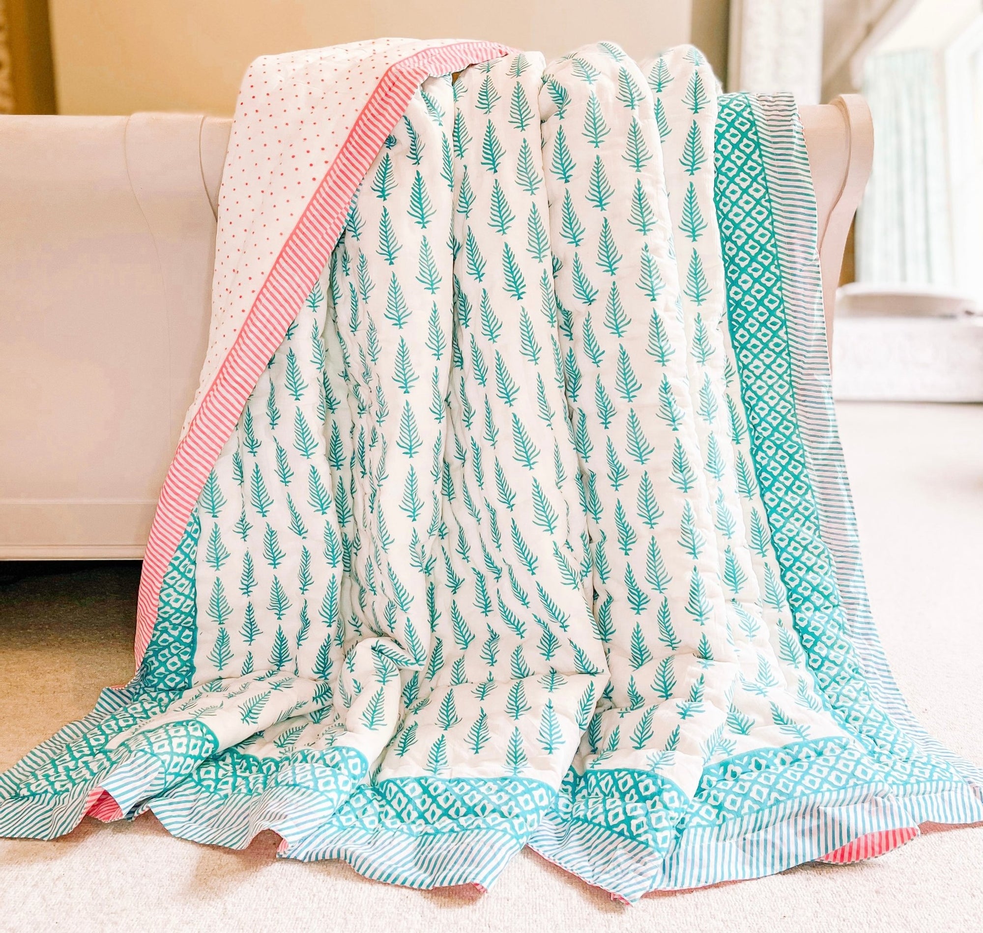 Bombaby block print blue quilt. King size bed. Handmade blue leaf print quilt with pink spots. Reversible. Ethically sourced bedding.